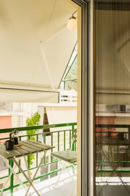 a glass door leading to a balcony with a table at 2 br cozy stylish apartment in Athens