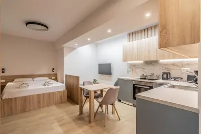 a kitchen and a bedroom with a bed and a table at Quiet Studio With Free Parking in Athens
