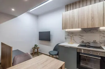 a kitchen with a stove and a table in a room at Quiet Studio With Free Parking in Athens