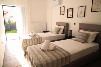 a bedroom with two beds and a window at Villa Achilleas by the sea in Anavissos