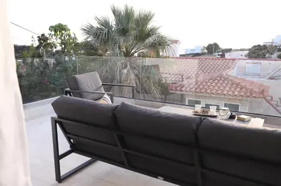 a couch sitting on top of a balcony at Villa Achilleas by the sea in Anavissos