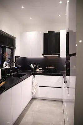 a kitchen with white cabinets and a black counter top at Villa Achilleas by the sea in Anavissos