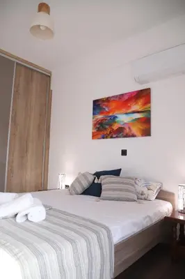 a bedroom with a bed and a painting on the wall at Villa Achilleas by the sea in Anavissos