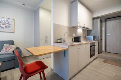 a kitchen with a table and a red chair in a room at Ilisia 2 person apartment by MPS in Athens