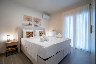 a white bedroom with a large bed with white sheets at Ilisia 2 person apartment by MPS in Athens