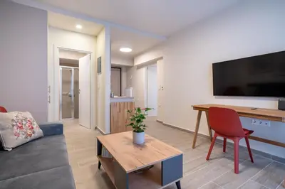 a living room with a couch and a desk with a television at Ilisia 2 person apartment by MPS in Athens