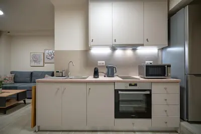 a kitchen with white cabinets and a microwave at Ilisia 2 person apartment by MPS in Athens