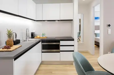 a kitchen with white cabinets and a table and chairs at Hestia - Asklipiou 9 in Athens