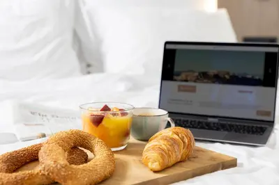 a wooden cutting board with pretzels and a cup of coffee and a laptop at Hestia - Asklipiou 9 in Athens