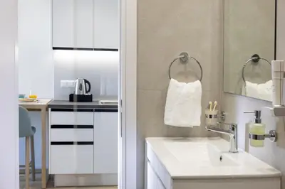 a white bathroom with a sink and a mirror at Hestia - Asklipiou 9 in Athens