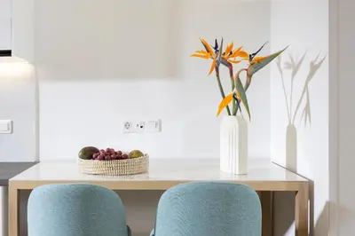 a table with two blue chairs and a vase with flowers at Hestia - Asklipiou 9 in Athens