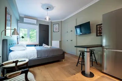 a bedroom with a bed and a table and a refrigerator at Kipseli 2 prsn studio by MPS in Athens