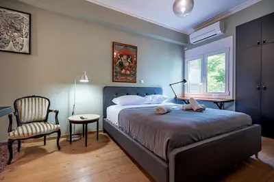 a bedroom with a bed and a chair and a window at Kipseli 2 prsn studio by MPS in Athens