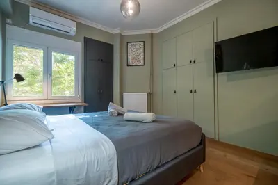 a bedroom with a large bed and a television at Kipseli 2 prsn studio by MPS in Athens