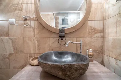 a bathroom with a large stone sink and a mirror at Kipseli 2 prsn studio by MPS in Athens