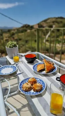 a table with plates of food and drinks on it at Keratea Hillside House in Keratea