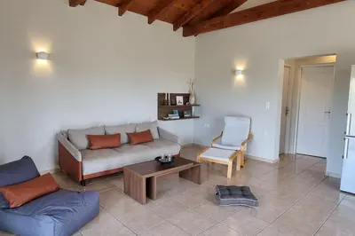 a living room with a couch and a table and a chair at Keratea Hillside House in Keratea