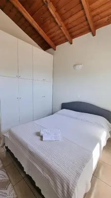 a bedroom with a large bed with white cabinets at Keratea Hillside House in Keratea