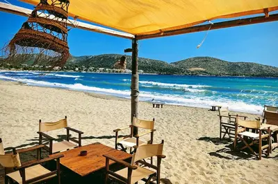 a wooden table and chairs on a beach at Keratea Hillside House in Keratea