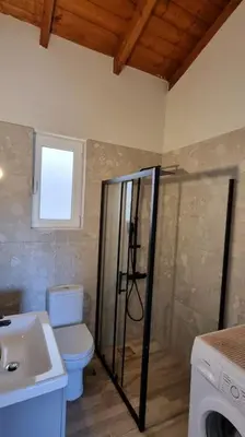 a bathroom with a toilet and a shower and a sink at Keratea Hillside House in Keratea