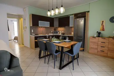 a kitchen with a wooden table and chairs in a room at Thyme Out - Modern Apartment in Egaleo-Athens in Athens