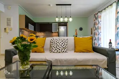 a living room with a couch and a vase of flowers at Thyme Out - Modern Apartment in Egaleo-Athens in Athens