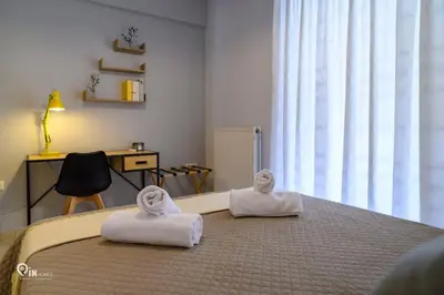 a bedroom with a bed with towels on it at Thyme Out - Modern Apartment in Egaleo-Athens in Athens