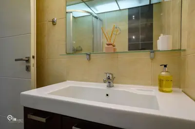 a bathroom sink with a mirror and a soap bottle at Thyme Out - Modern Apartment in Egaleo-Athens in Athens