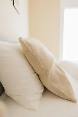 a pillow sitting on a bed next to a window at Modern 2BDR Apt - 2' to Metro - Direct to Acropolis in Athens