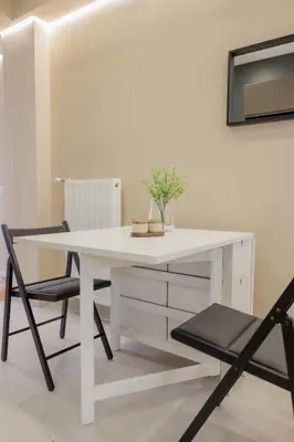 a white desk with two chairs and a vase on it at Modern 2BDR Apt - 2' to Metro - Direct to Acropolis in Athens