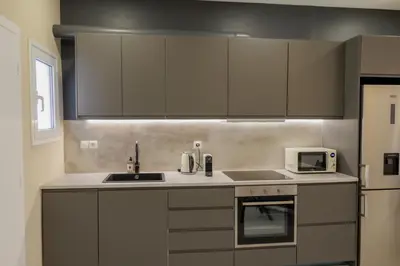a kitchen with white cabinets and a sink and a microwave at Modern 2BDR Apt - 2' to Metro - Direct to Acropolis in Athens