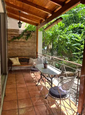 a patio with a table and chairs and a couch at Quiet Apartment with Garden View in Kolonaki in Athens