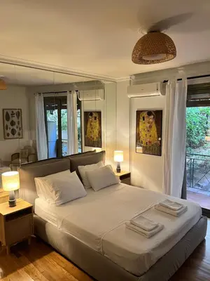 a bedroom with a large white bed with two lamps at Quiet Apartment with Garden View in Kolonaki in Athens