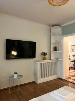 a living room with a flat screen tv on the wall at Quiet Apartment with Garden View in Kolonaki in Athens