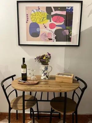 a table with a bottle of wine and a vase of flowers at Quiet Apartment with Garden View in Kolonaki in Athens