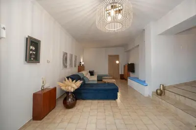 a living room with a blue couch and a table at Φ Villa by A&D Properties in Porto Rafti