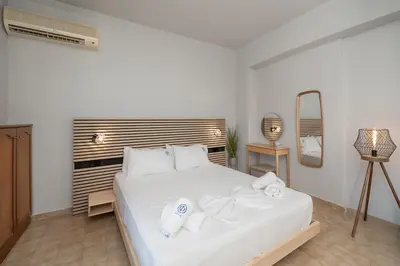 a bedroom with a white bed with towels on it at Φ Villa by A&D Properties in Porto Rafti