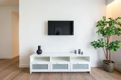 a white living room with a tv on a wall at Nostalgia 1-Bedroom Apartment in Athens in Athens