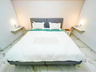 a bedroom with a large white bed with two lights at Cozy appartment Panathianiko Stadio in Athens