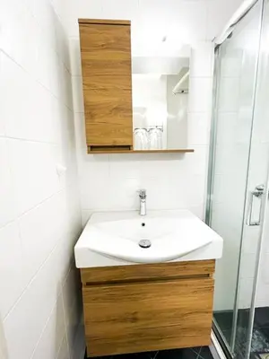 a bathroom with a white sink and a shower at Cozy appartment Panathianiko Stadio in Athens