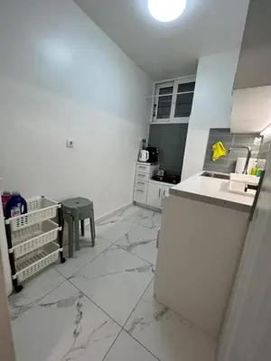a white kitchen with a counter and a sink at Cozy appartment Panathianiko Stadio in Athens
