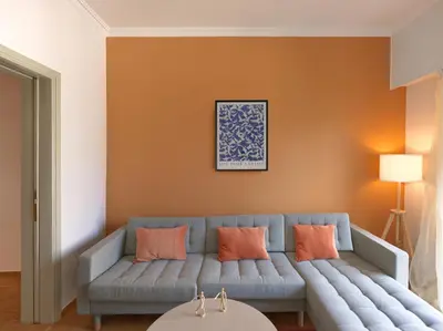a living room with a blue couch and orange walls at Marnis10 5th Right in Athens