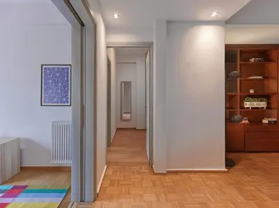 a hallway with white walls and a wooden floor at Marnis10 5th Right in Athens