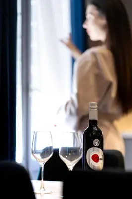 a woman sitting at a table with two wine glasses at Bueno Apartments by Athens Prime Hotels in Athens