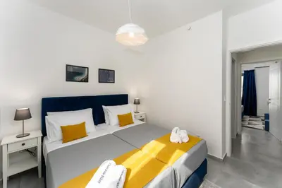 a bedroom with a large bed with yellow and blue at Bueno Apartments by Athens Prime Hotels in Athens