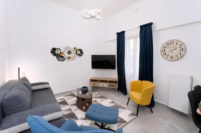 a living room with a couch and a clock on the wall at Bueno Apartments by Athens Prime Hotels in Athens