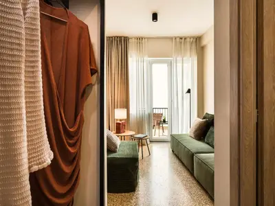 a living room with a green couch and a window at Anasa Hotel Athens in Athens