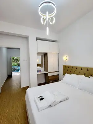 a bedroom with a large white bed and a chandelier at AHAMED GREEK SMPCO in Athens