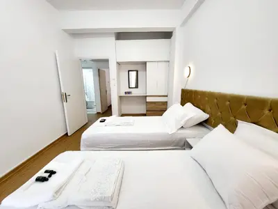 two beds in a hotel room with white sheets at AHAMED GREEK SMPCO in Athens
