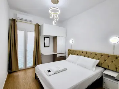a bedroom with a large white bed and a chandelier at AHAMED GREEK SMPCO in Athens